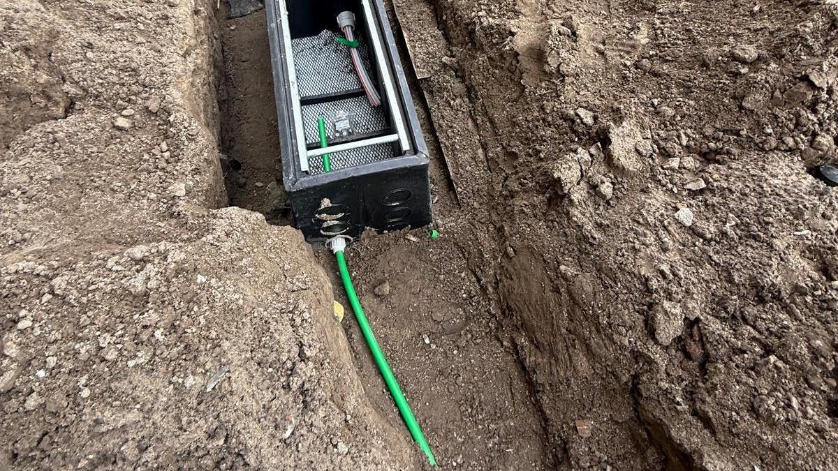 Handhole met invoerbuizen in de sleuf bij een woning in aanbouw