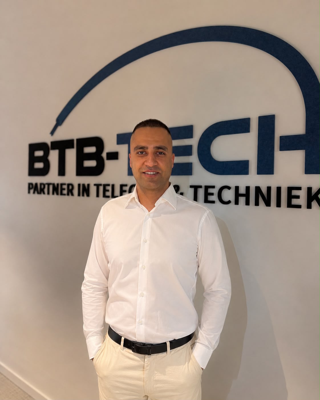 Achmed Almushat, Manager beheer Zuid bij BTB-Tech, voor de logowand op het hoofdkantoor