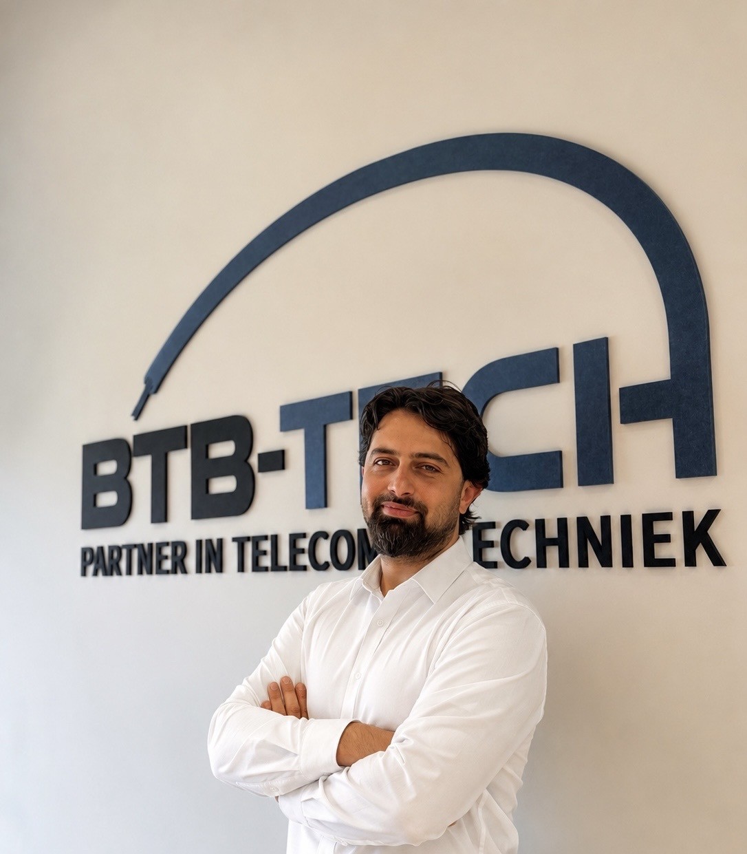Halil Cetinkaya, Manager beheer Noord bij BTB-Tech, voor de logowand op het hoofdkantoor