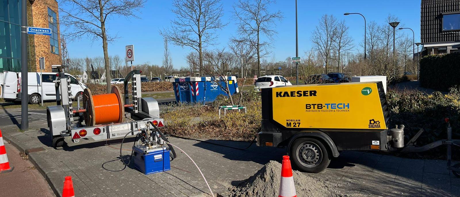 Afgezette werklocatie met haspelwagen en compressor